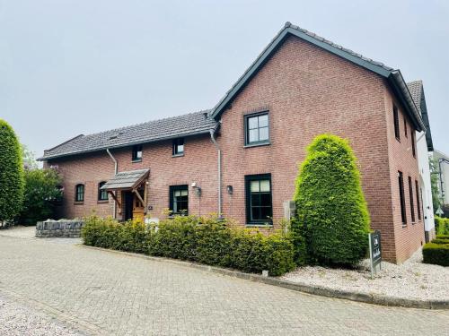 KlimmenAttractive Farmhouse in South Limburg with Terrace的前面有标志的红砖房子