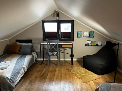 SpithamiSpithamn Village House的一间卧室配有一张床、一张书桌和一个窗户。