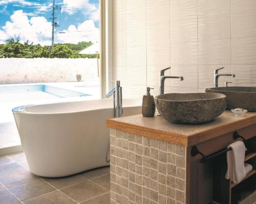 Fukaiコーラルテラス石垣島的浴室配有两个盥洗盆和浴缸。