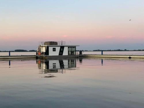 OffingawierModern houseboat in Offingawier with terrace的水面上一座小建筑