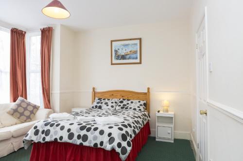 滨海绍森德Southend Guest House - Close to Beach, Train Station & Southend Airport的卧室配有黑白床和沙发