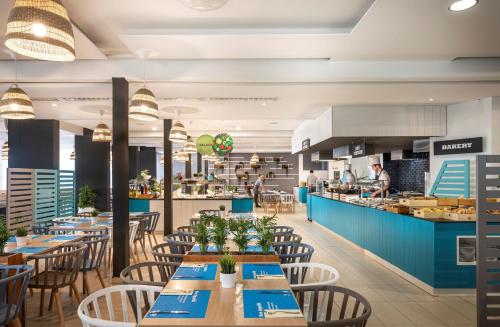 杜布罗夫尼克Club Dubrovnik Sunny Hotel的一间带桌椅的餐厅和一间厨房