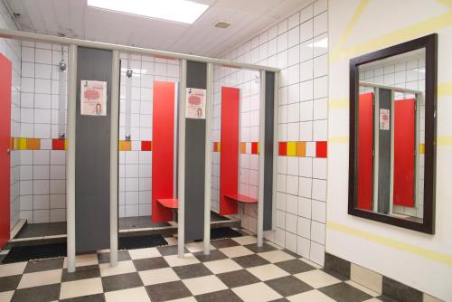 奥克兰银蕨背包客旅馆的浴室里一排铺着红白瓷砖的摊位