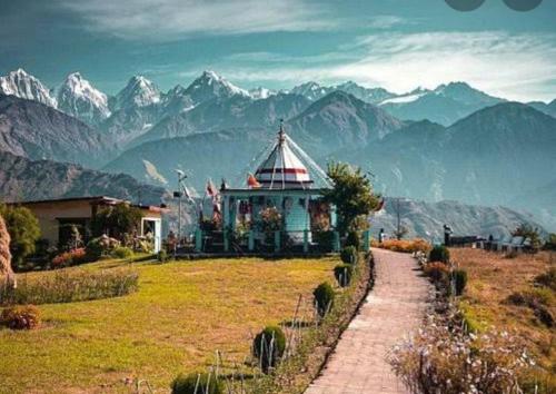 MunsyariComet Himalayan Paradise Homestay, Munsiyari的山丘上以山为背景的房子