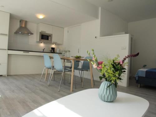 斯霍尔Stunning apartment in Schoorl North Holland you can bike to the beach的厨房以及带桌椅的起居室。