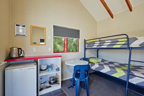 凯库拉凯库拉十佳假日公园酒店的宿舍间配有双层床和桌子。