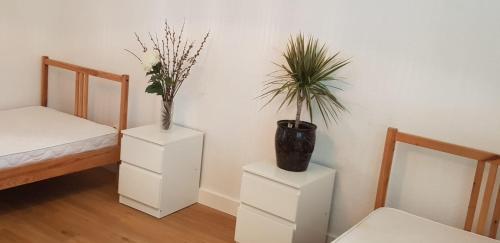 黑明根Apartment Hannover-Hemmingen的一间房间,配有两张白色桌子和植物