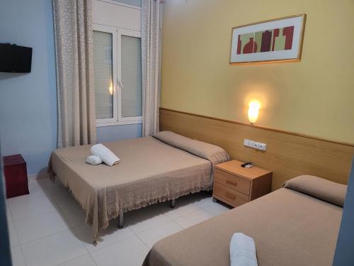 塞古德卡拉斐Hotel Sant Jordi的酒店客房设有两张床和窗户。