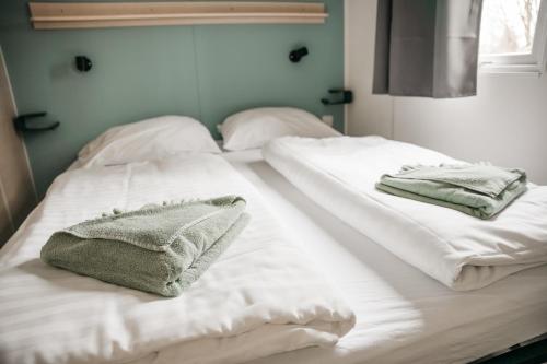 贝尔多夫Cahita Camping Belle-Vue 2000的客房内的2张白色床和毛巾