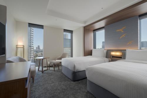 东京东京普乐美雅凯宾总统酒店的酒店客房设有两张床和电视。