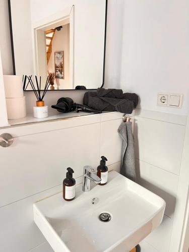 多斯滕Dachgeschoss-Maisonette-Apartment mit Klimaanlage的浴室设有白色水槽和镜子