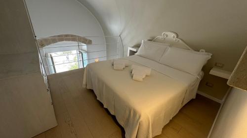 莫诺波利Residenza Garibaldi的卧室配有白色的床和2条毛巾
