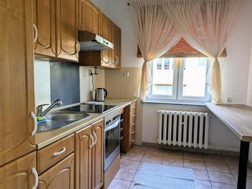 科沃布热格Muelle的厨房配有木制橱柜、水槽和窗户。