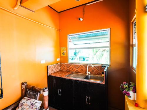 长滩岛Gracias Inn的橙色的厨房设有水槽和窗户