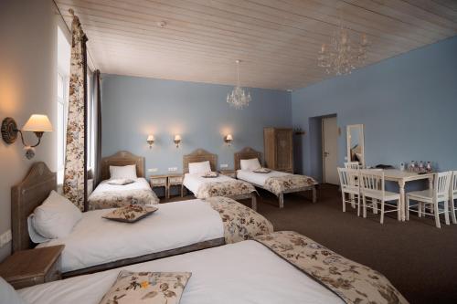 SileneSilene Resort & SPA Egles Villa的带三张床和桌椅的房间