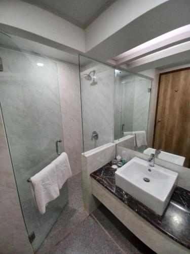 日惹Abadi Hotel Malioboro Yogyakarta by Tritama Hospitality的一间带水槽和大镜子的浴室