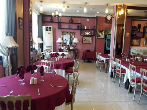 奥兰Hotel Les Ambassadeurs的一间带桌椅和红色桌布的用餐室