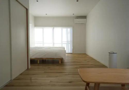 甲州Kajitsuno mieru yado - Vacation STAY 06979v的一间卧室配有一张床、一张桌子和一个窗户。