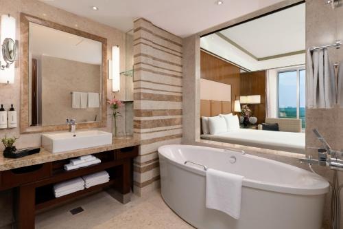 新德里新德里奥卡哈皇冠假日酒店的带浴缸、水槽和镜子的浴室