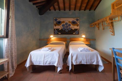 斯坎萨诺Sasseta Alta的一间设有两张带白色桌布的床的客房