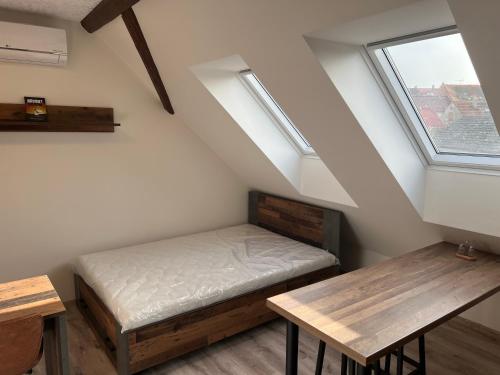 斯拉尼Zlonice - Ubytování 1kk的客房设有床、桌子和窗户。