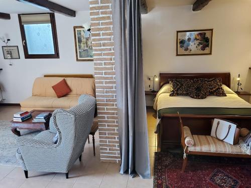 瓦尔玛德雷拉Relais Garden Lecco的一间卧室配有一张床、一张沙发和一把椅子