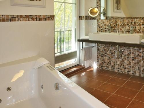 欧巴德伍斯图Scanhausvilla的带浴缸和窗户的大浴室