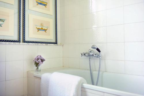 布奇内Fattoria Casabianca的白色的浴室设有浴缸和花瓶