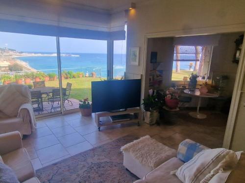 滨海阿雷尼斯Preciosa casa al borde de un acantilado的带电视的客厅,享有海景。
