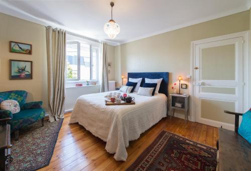 勒芒La Mancelle - Chambre d'hôtes的一间卧室配有一张床和一张蓝色椅子