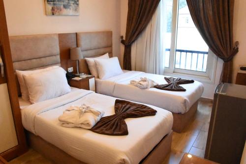 开罗Zamalek Army Hotel的两张位于酒店客房的床,配有毛巾