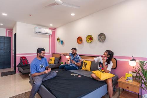 斋浦尔The Hosteller Jaipur, MI Road的三人坐在房间里的床上