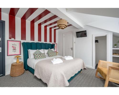 贝尔法斯特The Wellesley的一间卧室设有两张床和红色及白色条纹墙
