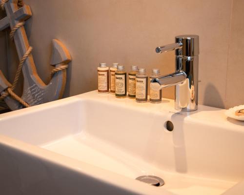 林道Ferien-Lodge Lindau - Private Sauna & nah am See的浴室水槽上装有四瓶除臭剂