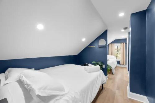 哥伦布5 Bedrooms Sleeps 14 - Hot Tub - 1 min to Fairgrounds的一间卧室设有两张床和蓝色的墙壁