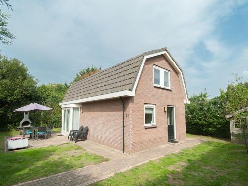 海滨诺德韦克Nice house with large garden in Noordwijk and near the sea的一座小砖房子,庭院里设有庭院