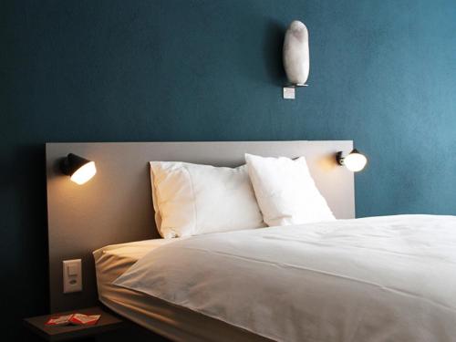 Siebnen斯托伯格酒店公寓的卧室配有一张带两盏灯的墙壁床。