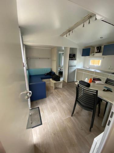 纳博讷普拉日Mobil home - Clim, TV - Camping Falaise Narbonne Plage 4 étoiles - 010的一间带桌子的客厅和一间厨房