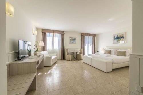 利尼亚诺萨比亚多罗Hotel Golf Inn的客厅配有白色沙发和电视