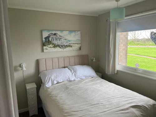 ScratbyLA BELLA CHALETS 2 - 155 Sunbeach Holiday Village Scratby的卧室配有白色的床和窗户