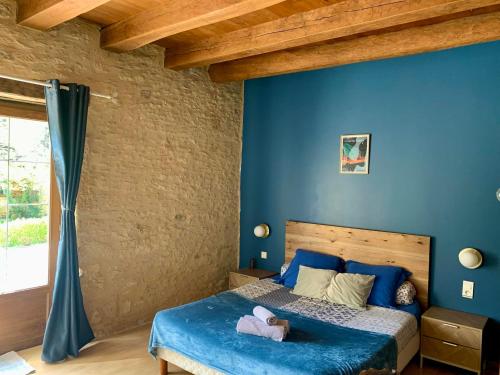 Marcillac-Saint-QuentinDomaine de Pech Mortier的一间卧室设有蓝色的墙壁和一张床