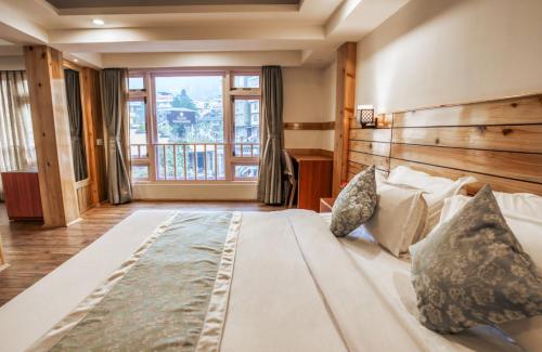 甘托克Gangtok Prime Hotel & Spa的一张大床,位于带大窗户的房间里