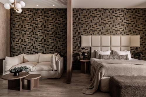 查加基恩Elegance Luxury Executive Suites - Adults Only的一间卧室配有一张床和一张沙发