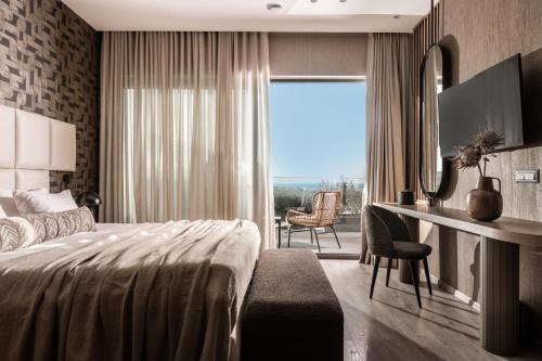 查加基恩Elegance Luxury Executive Suites - Adults Only的一间卧室配有一张床和一张带窗户的书桌