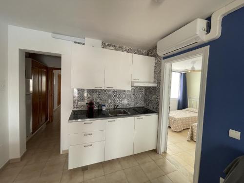 卡拉恩·布拉內斯Mitjaneta Apartamento con piscina的厨房配有白色橱柜和水槽