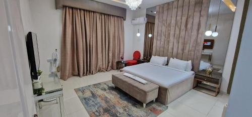 MaiyegunLuxury 3-Bed house in gated estate with pool Lekki的一间卧室配有一张床、一张沙发和一台电视