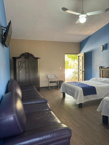 AmecaFrutos Hotel的一间卧室配有一张床和一张沙发