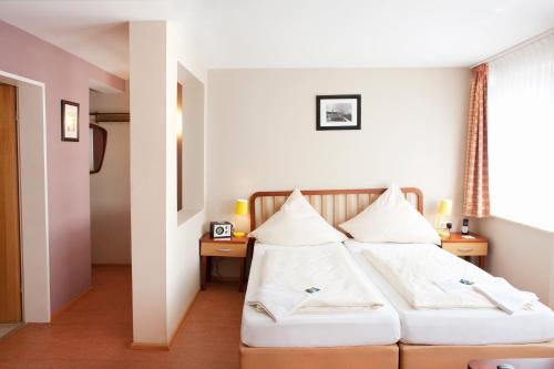 黑尔戈兰岛埃尔格兰德克拉西克酒店的一间卧室配有两张带白色枕头的床