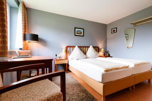 黑尔戈兰岛埃尔格兰德克拉西克酒店的配有一张床和一张书桌的酒店客房