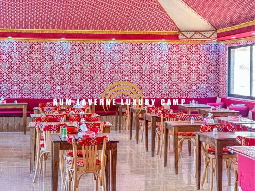 瓦迪拉姆Rum Laverne Luxury Camp的用餐室配有桌椅和粉红色的墙壁
